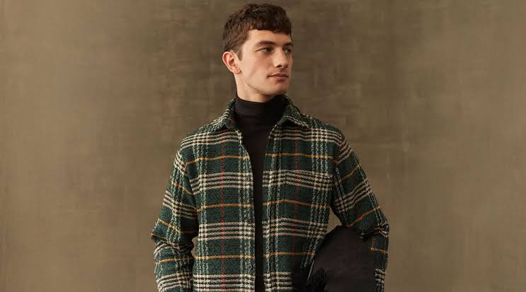 Man styling flannels over a hoodie with denim and trainers in 2026